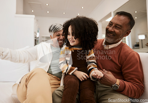 Image of Grandparents, home smile and family kid, grandma and grandfather laughing, having fun and enjoy quality time together. Living room couch, grandfather and grandmother play with child during retirement