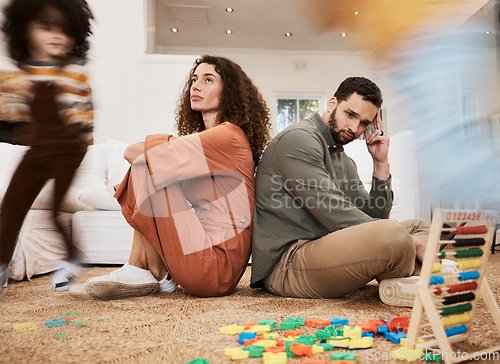 Image of Parents, floor and stress with kid running, toys and motion blur for speed, naughty or overwhelmed in house. Mother, father and child on carpet, living room or family home with chaos, mess or burnout