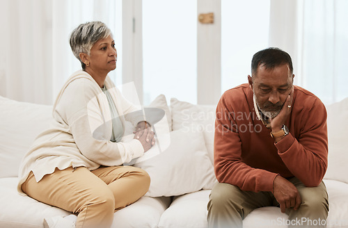 Image of Talking, conflict and a senior couple on the sofa for a conversation about marriage stress. Sad, house and an elderly man and woman on the couch speaking about a divorce or relationship problem