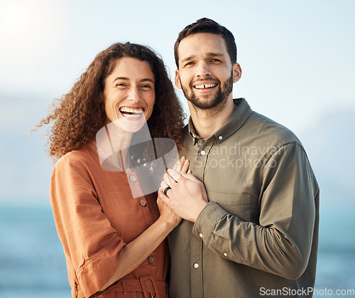 Image of Couple, portrait and smile at beach, love and excited with holding hands, care and romance on holiday. Man, woman and happy for marriage, vacation and bonding by ocean, waves and outdoor in Naples