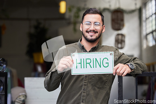 Image of Portrait, man and we are hiring sign with recruiting, happy and smile from business owner. Male person, store and entrepreneur with recruitment poster and job search signage with manager and employee