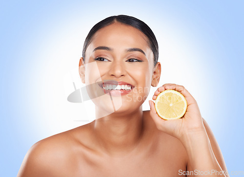 Image of Beauty, lemon and happy studio woman with citrus fruit for organic skincare glow, facial detox or natural cosmetics. Happiness, spa and clean self care model with vitamin C product on blue background