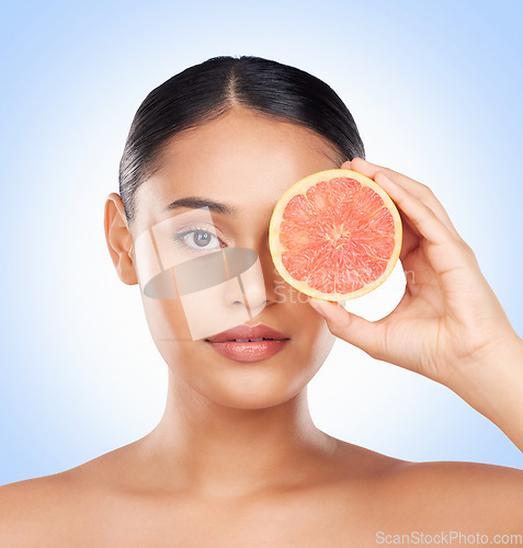 Image of Beauty skincare, portrait and woman with grapefruit for organic collagen treatment, natural self care or fruit benefits. Vitamin C, citrus product or studio face of wellness person on blue background