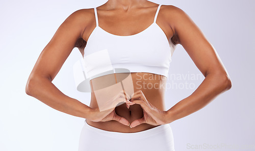 Image of Heart, hands and stomach of woman for wellness, nutrition, fitness and diet in studio on white background. Closeup, person and nutritionist in underwear for gut health, colon and transformation