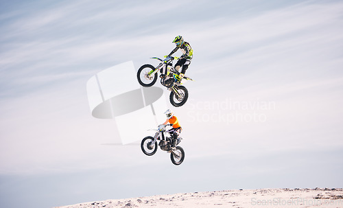Image of Sports, jump and people on motorcycle driving on sand, beach or training for a challenge, competition or desert rally. Dirt, motorbike and men in fearless extreme action, stunt or jumping in the air