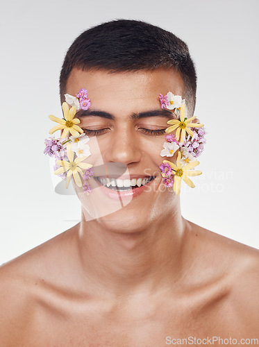 Image of Floral, face or happy man with flowers for beauty, natural cosmetics or wellness in studio on white background. Nature aesthetic, smile or model laughing at eco friendly skincare or spring art design