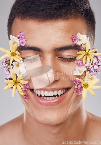 Image of Relax, face or happy man with flowers for beauty, natural cosmetics or wellness in studio on white background. Nature aesthetic, smile or model laughing at eco friendly skincare or spring floral art