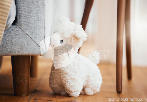 Image of Teddy bear, empty room and toy on floor of home, background and alone by sofa in lounge of house. Abandoned, lonely and stuffed animal for grief, mental health, loss and sad or security by couch