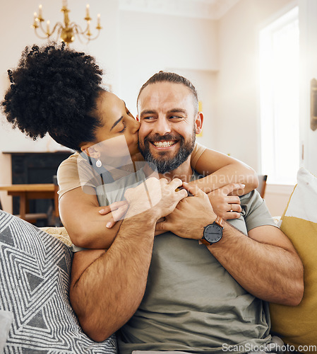 Image of Happy couple, hug and kiss on sofa in home, living room or bonding in apartment with love in marriage or relationship. Man, smile and woman embrace or support partner on couch or relax together