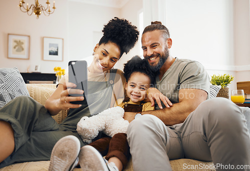 Image of Interracial parents, child and selfie on sofa, smile and hug for love, bonding and memory on web blog. Mom, dad and kid for photography, profile picture and happy for social media app in family house