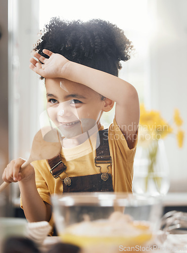 Image of Child in kitchen, baking with wooden spoon and cake flour on face, little baker making breakfast or cookies. Learning, cooking and happy boy chef in home with mixing bowl, tools and smile in morning.