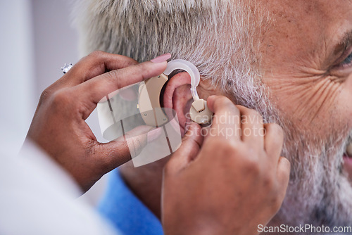 Image of Healthcare, hands and doctor with hearing aid for man for communication support. Closeup, medical and a nurse with an implant for a patient with a disability for help with listening and conversation