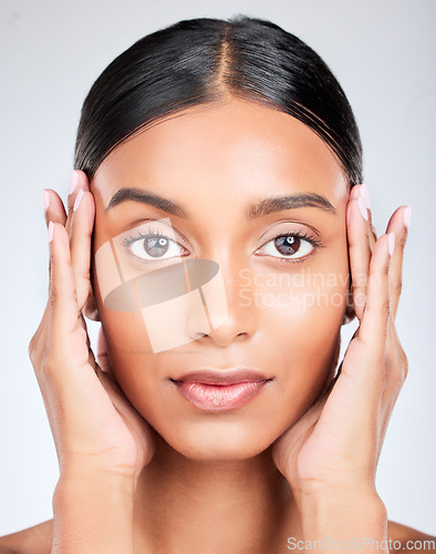 Image of Studio portrait of Indian woman with hands for skincare, beauty and cosmetics on white background. Dermatology, spa and serious face of isolated person for wellness, satisfaction and facial treatment