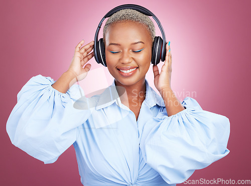 Image of Music, headphones and happy black woman in studio for radio, streaming or audio subscription on pink background. Podcast, earphones and African lady model smile for album track or feel good playlist