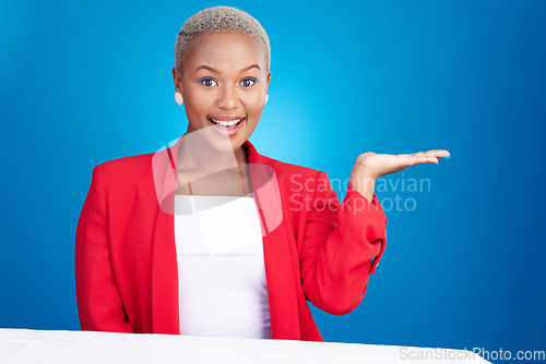 Image of Portrait, black woman and hand holding in studio for promo, announcement or coming soon deal on blue background. Happy, face and African lady model show mockup, space or prize, giveaway or offer info