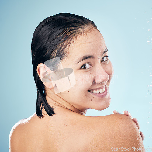 Image of Shower, portrait or happy woman cleaning back, hair or body for wellness in studio on blue background. Smile, beauty or wet person washing or grooming for healthy natural hygiene or skincare to relax