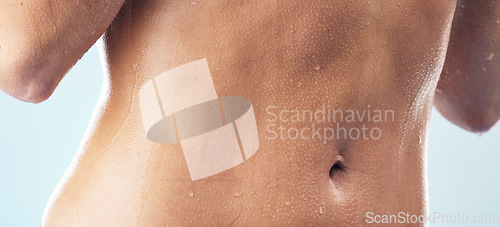 Image of Body care, cleaning and stomach of woman in a shower for wellness, hygiene and skincare in studio closeup. Water splash, zoom and abdomen of female model in bathroom for beauty, routine or daily care