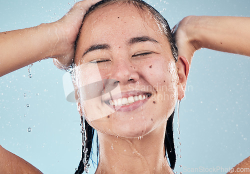 Image of Shower, face or happy woman cleaning hair for skincare or wellness in studio on blue background. Shampoo, beauty model or wet female person washing or grooming for healthy natural hygiene to relax