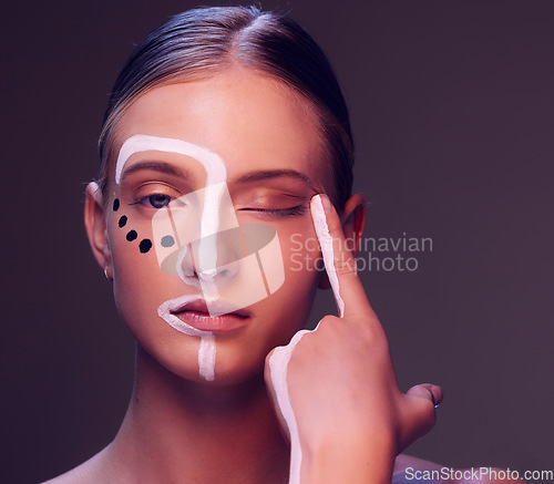 Image of Woman, skin and paint in studio, wink and closeup for art, wellness or fantasy with cosmetic by dark background. Girl, model and facial painting for eyes, creativity or pattern with makeup for change