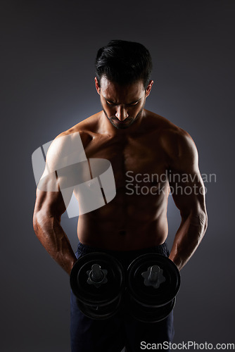 Image of Muscle, dark studio and man with dumbbell challenge, arm workout development and training determination. Bodybuilder progress, gym equipment and sports person doing weightlifting on grey background