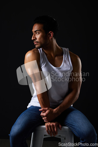 Image of Thinking, muscle and sexy man on chair in studio with fitness inspiration, beauty aesthetic and sensual fashion. Erotic art, sexual body and male model sitting on black background with dark lighting.