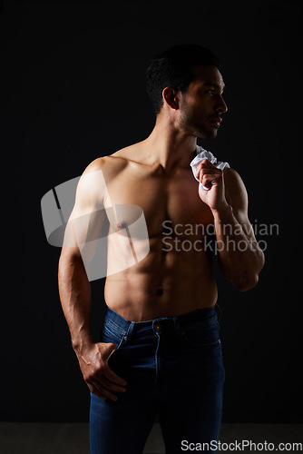 Image of Sexy, muscle and topless man on dark background with fitness inspiration, beauty aesthetic and sensual fashion. Erotic art, sexual body and male model in studio thinking in fantasy lighting and jeans
