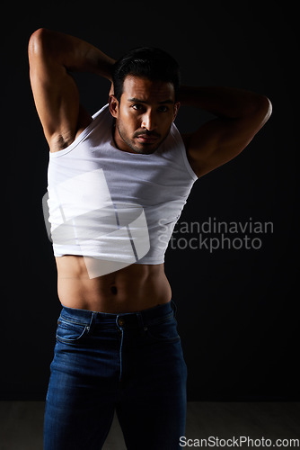 Image of Fitness, fashion and muscle with man in studio for strong, body and health. Sports, wellness and workout with person and remove tshirt on dark background for bodybuilder, gym and athlete motivation
