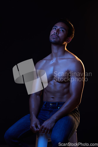Image of Topless, sexy and man in neon studio for fitness inspiration, beauty aesthetic or sensual fantasy. Erotic art, sexual body and male model thinking with muscle, black background and dark blue lighting