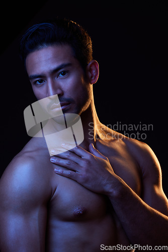 Image of Sexy, dark portrait and man on black background in fitness inspiration, beauty aesthetic or sensual fantasy. Erotic, sexual body and topless seductive male model with muscle, studio and neon lighting