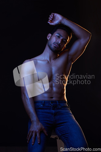 Image of Bodybuilder man, abs and dark in studio portrait, jeans or muscle for healthy body by black background. Young guy, fitness and silhouette with face, stomach or strong for health, shirtless or fashion