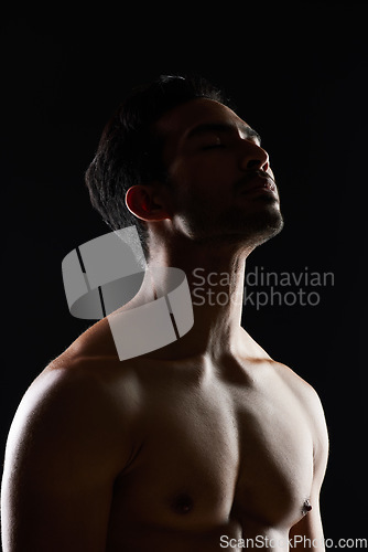 Image of Bodybuilder man, muscle and shadow in studio with wellness, healthy body and black background. Young guy, fitness and silhouette in dark, thinking and strong with ideas, health and shirtless for art