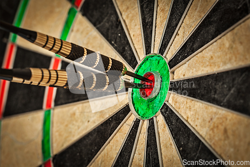 Image of Three darts in bull's eye close up