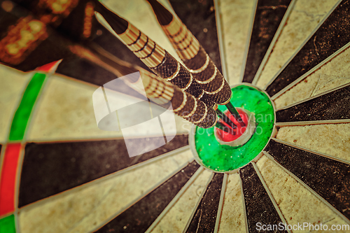 Image of Three darts in bull's eye close up