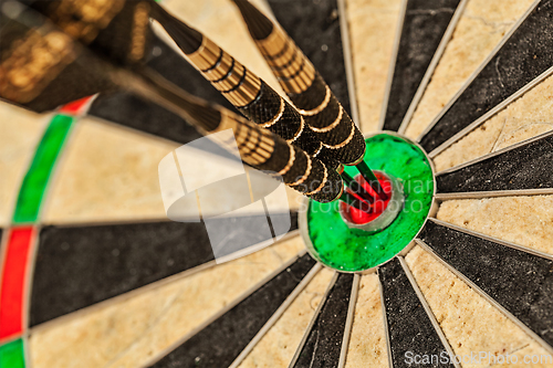 Image of Three darts in bull's eye close up