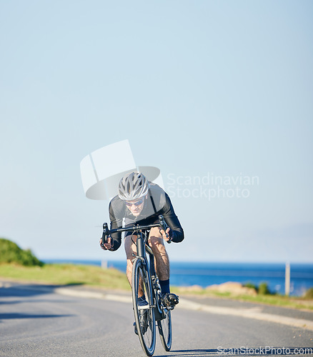 Image of Speed, fitness and cyclist on bicycle on road in mountain with blue sky, exercise adventure trail and speed. Cycling race, nature and man with bike for fast workout, training motivation or energy.