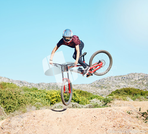 Image of Action, air and man cycling in nature training for a sports competition on trail or path on mountain. Freedom, stunt or cyclist athlete riding bicycle to jump for cardio exercise, fitness or workout