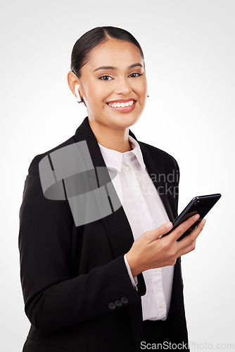 Image of Portrait, phone and earphones with a business woman in studio on a white background for communication. Smile, networking and music with a happy young employee typing a text message on her mobile