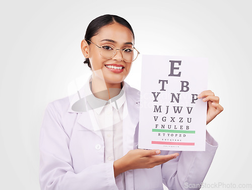 Image of Woman, portrait and chart in eye exam, letter or vision of optometrist in healthcare or sight against a studio background. Happy doctor smile with glasses in optometry assessment, diagnosis or test