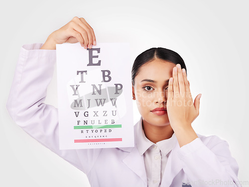 Image of Portrait, poster and eye test with a woman optician in studio on a white background for vision or eyesight. Face, medical and a serious young doctor in a clinic or optometry office for a visual exam