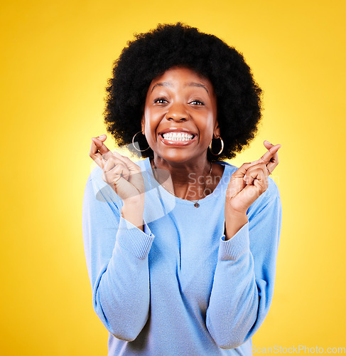 Image of Woman, fingers crossed and excited portrait in studio for hope, trust and optimism for winning, prize and lottery. African model wish for luck, bonus promotion or giveaway winner on yellow background