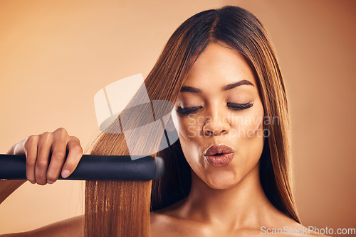 Image of Excited, hair straightener and a woman in studio for beauty, cosmetics or appliance. Aesthetic model on brown background for wow heat treatment, healthy results and hairdresser or salon flat iron