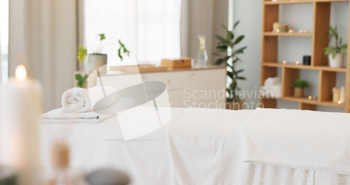 Image of Wellness, relax and a massage table on an empty spa background for luxury wellness or treatment. Health, zen and hospitality with candles for peace or aromatherapy a room of a modern beauty salon