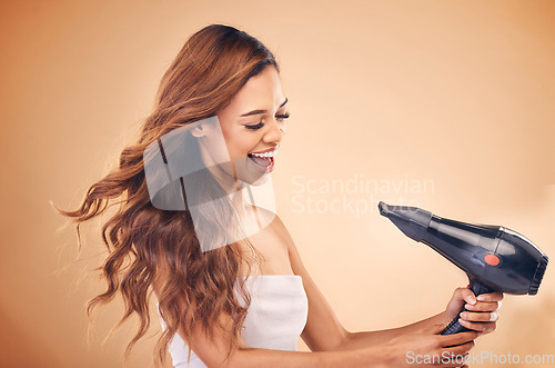 Image of Hair dryer, wind and a woman in studio for beauty, cosmetics and shine. Excited aesthetic model person on brown background for heat treatment, healthy results and hairdresser or salon blow out mockup