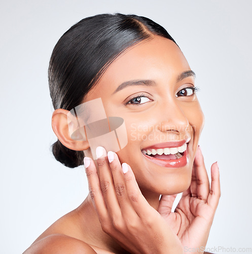 Image of Portrait, happy woman and touch face in studio for pride in skincare, aesthetic glow or healthy dermatology on white background. Young indian model, natural beauty and smile for clean facial cosmetic