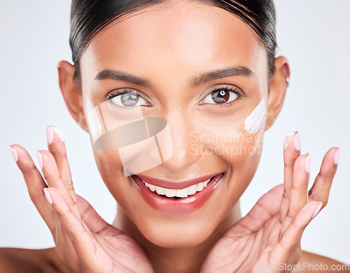 Image of Portrait, cream and woman with dermatology, beauty and cosmetics on a white studio background. Face, person and model with lotion, shine and glow with moisturiser, creme and skincare with aesthetic