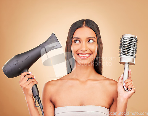 Image of Hairdryer, brush and young woman in studio with clean salon treatment hairstyle for wellness. Health, hair care and Indian female model with tools for haircut maintenance isolated by brown background