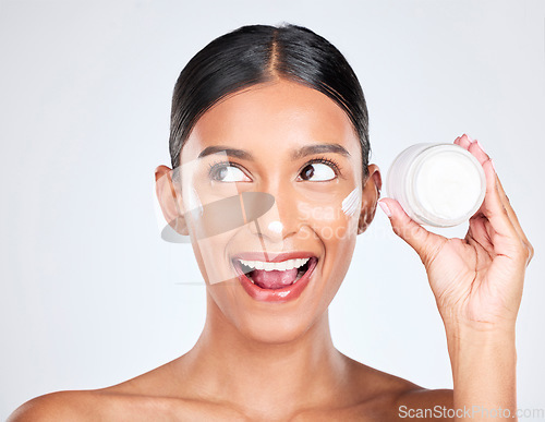 Image of Woman, happy surprise with cream on face and beauty, moisturizer and skincare with container on white background. Cosmetics product, lotion or sunscreen, facial and skin with dermatology in studio