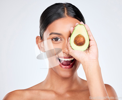 Image of Avocado, portrait and natural skincare of woman in studio for vitamin c benefits, eco cosmetics and nutrition. Face of happy indian model, healthy food and beauty for omega 3 diet on white background