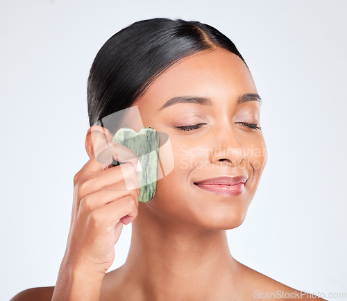 Image of Woman, face and gua sha, natural beauty and tools with jade stone for skincare isolated on white background. Facial massage, facelift and grooming with skin glow, dermatology and wellness in studio