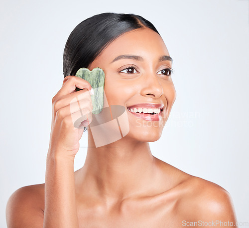 Image of Woman, skin and gua sha, natural beauty and tools with jade stone for skincare and face on white background. Facial massage, facelift and grooming with glow, dermatology and wellness in studio